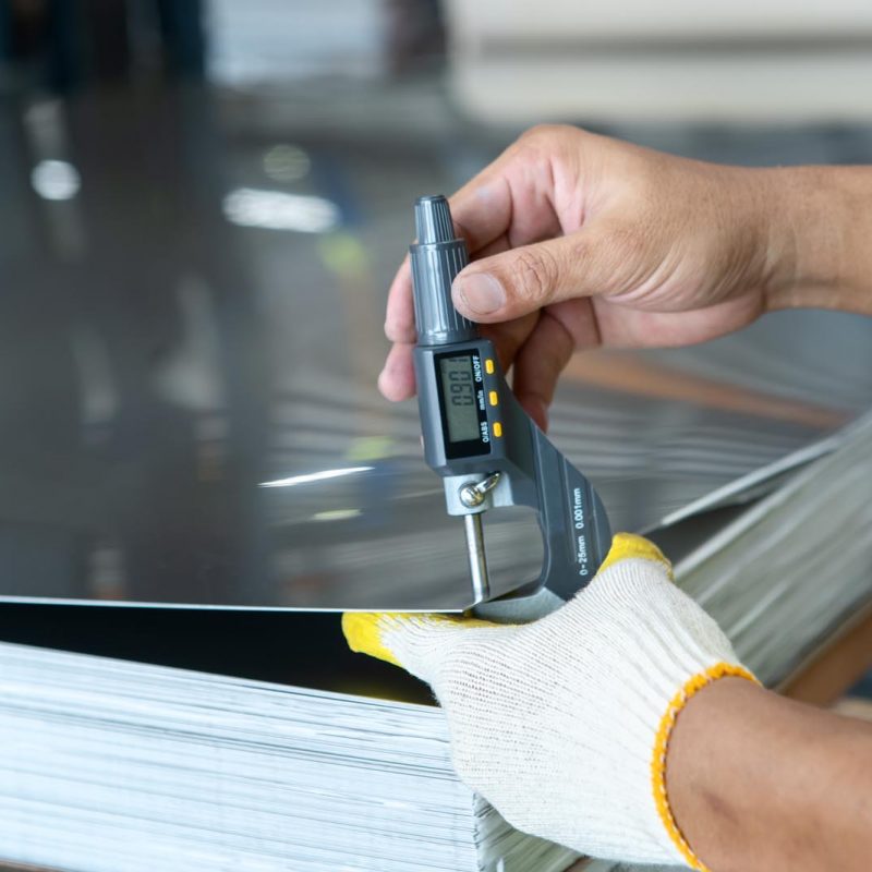 The photo shows how to measure how thick of the metal sheet by using digital thickness gauge.